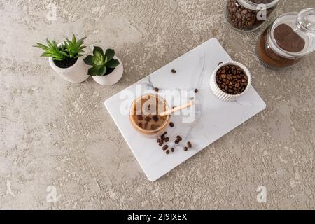 https://l450v.alamy.com/450v/2j9jxex/coffee-latte-mocha-with-milk-in-a-modern-glass-in-the-form-of-a-can-on-a-white-marble-board-and-a-table-made-of-concrete-a-trend-drink-top-view-2j9jxex.jpg