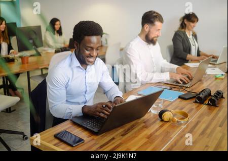 Diverse businesspeople working on laptops in office Stock Photo