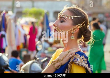 portrait indian beautiful Caucasian woman in traditional blue dress.hindu model with golden kundan jewelry set bindi earrings and nose ring piercing Stock Photo