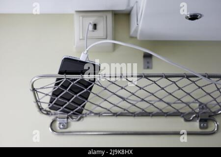 A smartphone is charging in a compartment car of a passenger train using a special socket Stock Photo