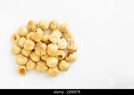 Pile of fresh organic roasted and peeled hazelnut kernels, isolated on white background Stock Photo