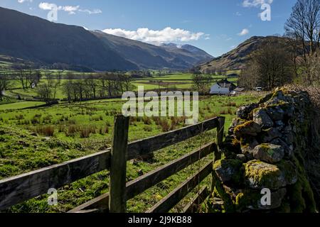 View along St John's in the Vale farmland towards snow on Helvellyn mountain range spring late winter Lake District National Park Cumbria England UK Stock Photo