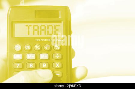 Calculator with text Trade on sunny beach background. Business stock trading concept Stock Photo