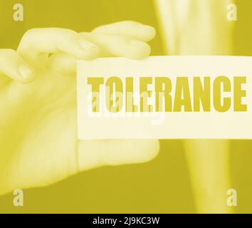 Tolerance words on a card in businessman hand. Social concept against discrimination at workplace Stock Photo