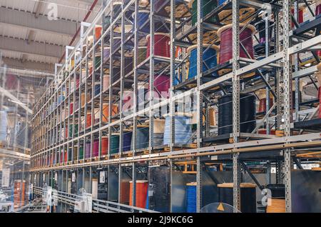 Large industrial metal rack with cables. Colored cable wound on spools Stock Photo