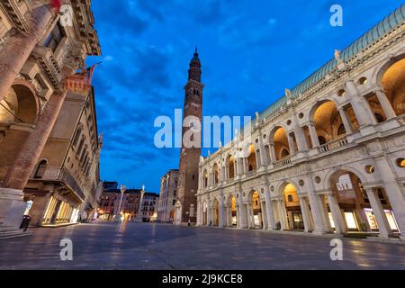 Palazzo della Regione or Basilica Palladian (right). Torre di Piazza with Palazzo del Monte di Pieta (lef) in Piazza dei Signori at twilight, Vicenza. Stock Photo