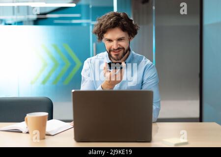 Smiling man working and talking on phone at office Stock Photo