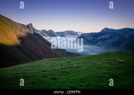 Landscape at dawn where we see the mountains and the valley of the Somiedo Natural Park in Asturias, Spain, with low clouds or fog in the valley. Idyl Stock Photo