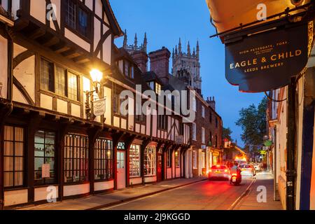 Evening on High Petergate in York, England. York Minster towers in the distance. Stock Photo