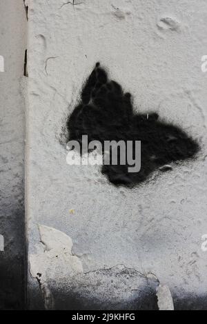 Beautiful monarch butterfly fluttering about while painted on a city wall. Stock Photo