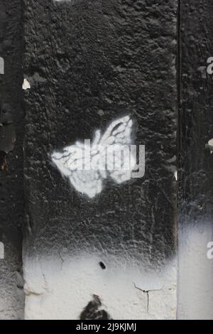 Beautiful monarch butterfly fluttering about while painted on a city wall. Stock Photo