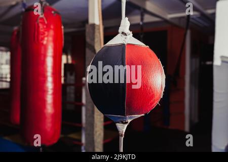 Punching and speed bags in boxing gym hanging, red and black, no people Stock Photo