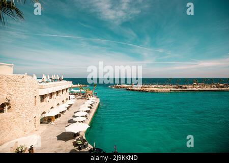 Ocean view of a resort in Hurghada Egypt with sun beds and resort umbrellas around a beautiful turquoise blue harbor Stock Photo