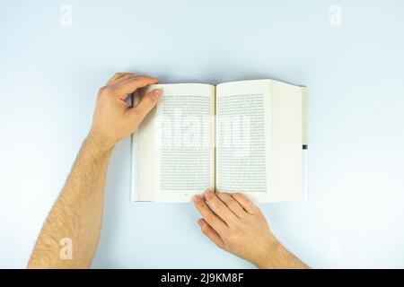 Man hands with open book page isolated on white background, reading book concept, studying and learning idea, top view of book Stock Photo