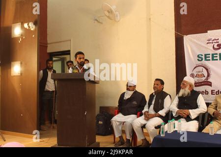 Muslim man giving a speech on a pedestal in front of an audience Stock Photo