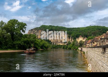 La Roque-Gageac, France - 12 May, 2022: the picturesque French village of La Roque-Gageac with traditional wooden Gabare river barge on the Dordogne R Stock Photo