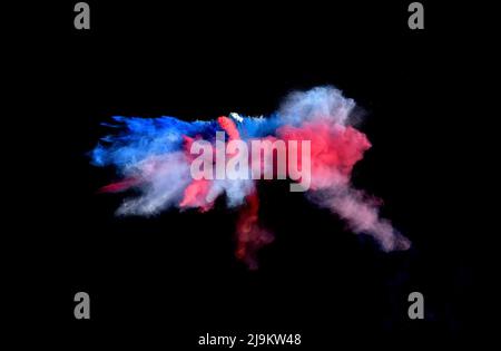 Red, white and blue forms of powder paint combined  together explode in front of a black background to give off fantastic powder paint explosions. Stock Photo