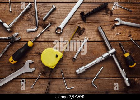 Flat lay with DYI composition of various work, carpentry tools knolled on brown wooden decks background pattern working table. Top view on new hand tool set for repair and construction kit, overhead Stock Photo