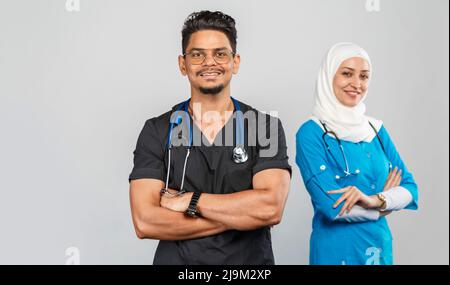 beautiful muslim doctor woman and indian nurse in glasses discuss tasks. portrait of beautiful medical workers with stethoscopes. Medical help, insura Stock Photo