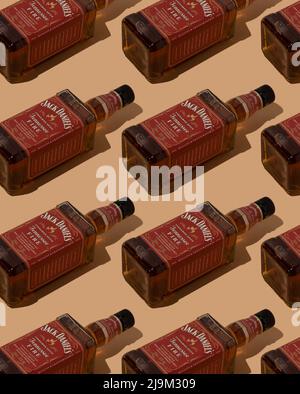 Pattern whiskey bottle Jack Daniels Red label. Bottles background. Jennessee fire cinnamon liqueur tennessee whiskey. Spice alcohol drink. Ukraine, Kyiv - May 17, 2022. Stock Photo