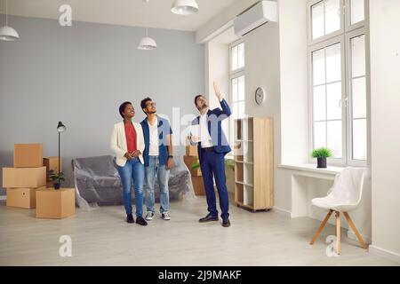 Real estate agent or realtor giving potential buyers tour around new house or flat Stock Photo