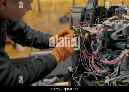 Professional worker fixing coffee machine in workshop Stock Photo
