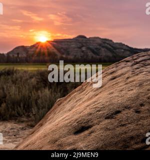 Sunburst Over Ridge and Cannonball Formation in Theodore Roosevelt National Park Stock Photo