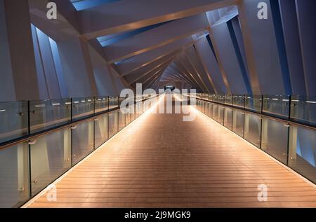 Beautiful view of the illuminated twisted bridge at the Dubai canal boardwalk, Dubai. Stock Photo