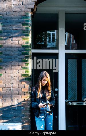Side view of crop passenger sitting in aircraft against window and browsing smartphone Stock Photo