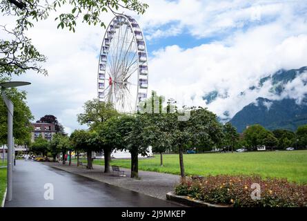 View of a giant Ferris wheel at the Hohematte park in Interlaken , Switzerland , set against a blue cloudy sky. Stock Photo