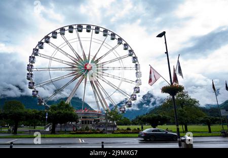 View of a giant Ferris wheel at the Hohematte park in Interlaken , Switzerland , set against a blue cloudy sky. Stock Photo