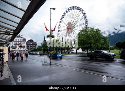 View of a giant Ferris wheel at the Hohematte park in Interlaken , Switzerland , set against a blue cloudy sky. Stock Photo