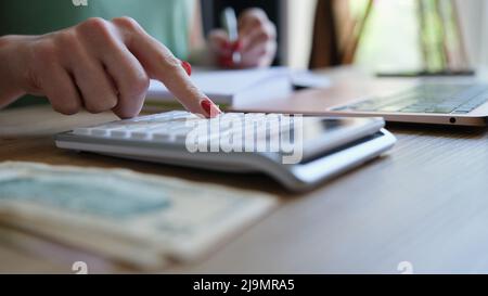 Businesswoman hand using calculator and working with laptop Stock Photo