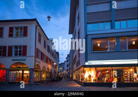 Chur, Switzerland. Picturesque view of the Chur village  with old historic buildings, alpine mountains and flowing Rhine river captured in night Stock Photo