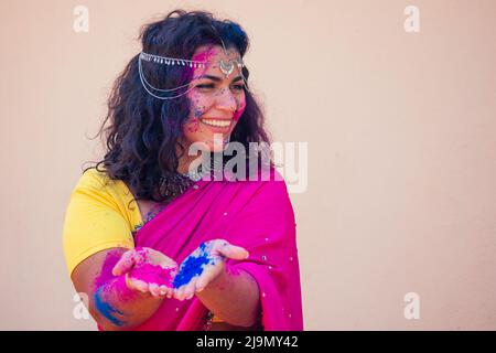 Holi Festival Of Colours. Portrait of happy indian girl in traditional hindu sari on holi color . india woman silver jewelry with powder paint on Stock Photo