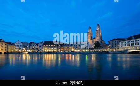 Munsterbrucke and Grossmunster church over the river Limmat during blue hour at Zurich, Switzerland. Stock Photo