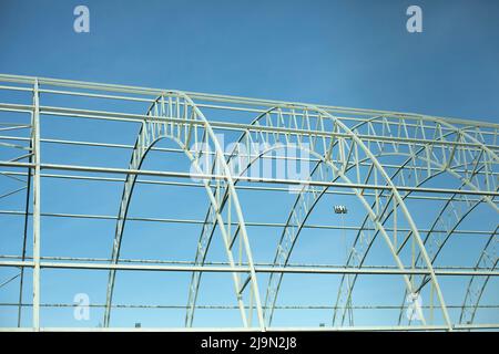 Basis for warehouse. Metal beams. Details of construction of sports complex. Steel details against blue sky. Stock Photo