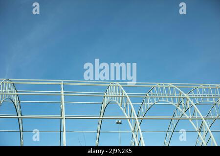 Basis for warehouse. Metal beams. Details of construction of sports complex. Steel details against blue sky. Stock Photo