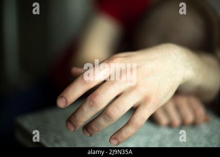 Hand of sleeping person. Guy fell asleep sitting down. Hand of drunk guy. Stock Photo