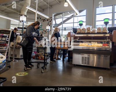 Mill Creek, WA USA - circa May 2022: View of people waiting in line to checkout at a cash register inside a Town and Country grocery store. Stock Photo