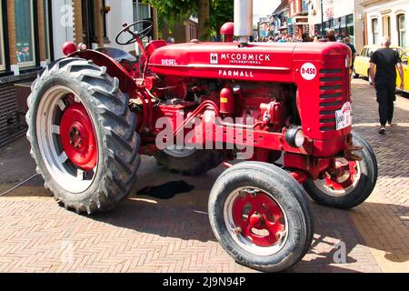 Vintage red McCormick International Farmall  B450 tractor on a classic car show in Uithuizen, Groningen, the Netherlands. Stock Photo