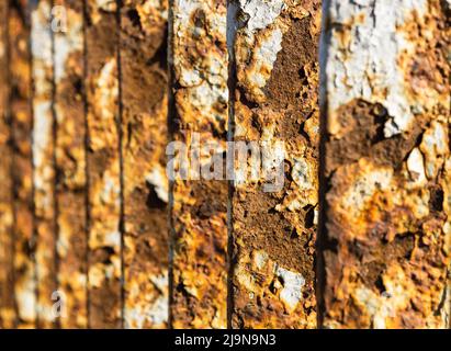 Metal bridge railing with corrosion, rust, deep cracks, and paint flaking texture Stock Photo