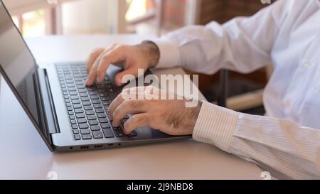 Man typing on laptop, teleworking at home. Stock Photo