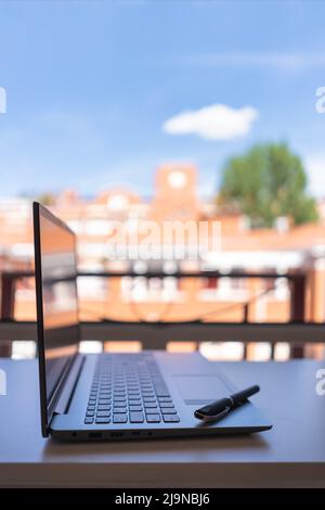 Laptop on the terrace prepared to telework with beautiful views of the city. Stock Photo
