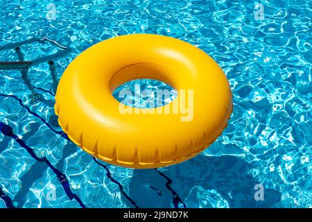 Yellow ring floating in refreshing blue swimming pool Stock Photo