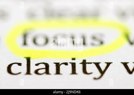 Close up of typed word clarity with blurred word focus circled in yellow fluorescent highlighter pen and printed in black ink on white ink jet paper Stock Photo
