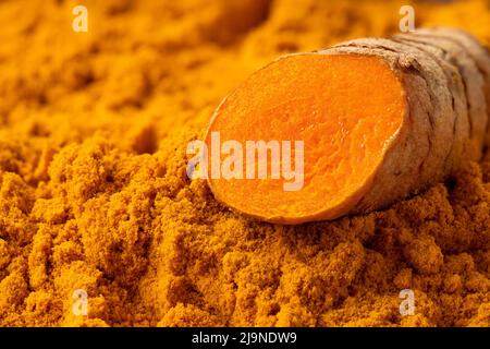 Sliced turmeric root on ground turmeric. Stock Photo