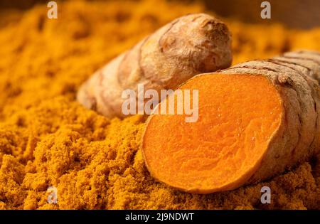 Sliced turmeric root on ground turmeric. Stock Photo
