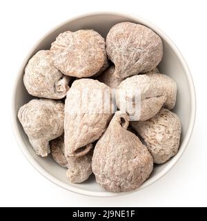 Dusted dried baby figs in a white ceramic bowl isolated on white. Top view. Stock Photo