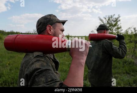 Service members of pro-Russian troops carry leaflet shells at their combat positions in the Luhansk region, Ukraine May 24, 2022. REUTERS/Alexander Ermochenko